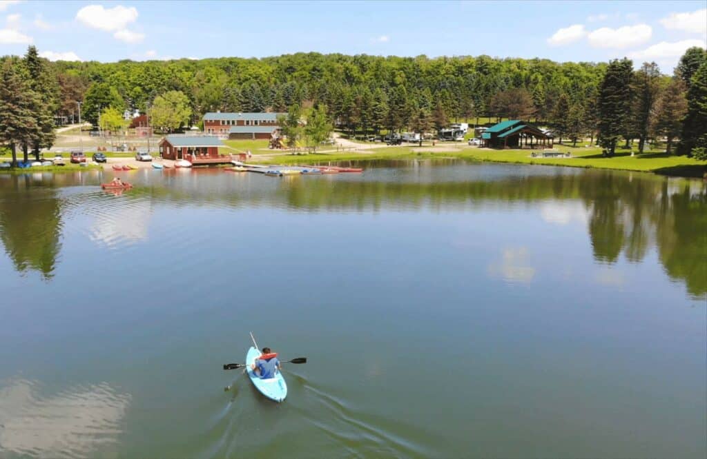 A person is paddling a kayak on Rainbow Lake.