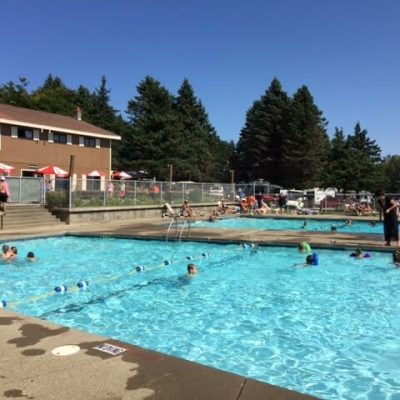 A large swimming pool in western New York with people playing in it.